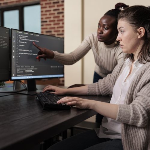 Blockchain engineer pointing out mistake in network security software line code. Cybernetics developers engineering system updates and processing data blocks uploaded by artificial intelligence.